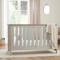 White and dove grey cot bed with vertical slats and oak top rail, with folded blanket