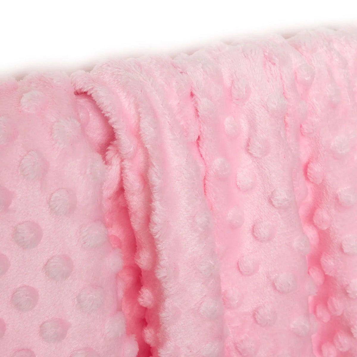 Pink fleece baby blanket corner with raised dot texture and soft rolled edge.