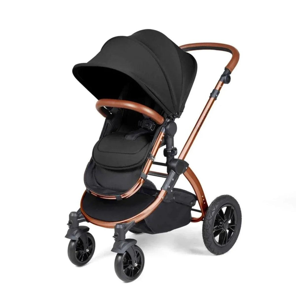Black pushchair with bronze handlebar, tan-trim accents, and large front wheels
