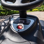 Matte black ride-on push car dashboard with steering controls and red horn button