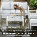White outdoor sofa with gray cushions beside a wood-effect slatted coffee table