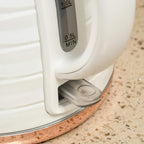 Cream-white electric kettle base with water outlet and removable spout filter