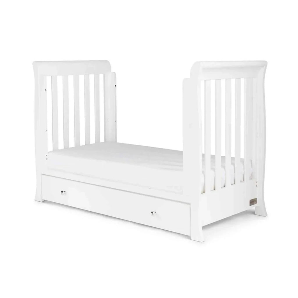 White mini cot bed with slatted rails and drawer front, showing end panels
