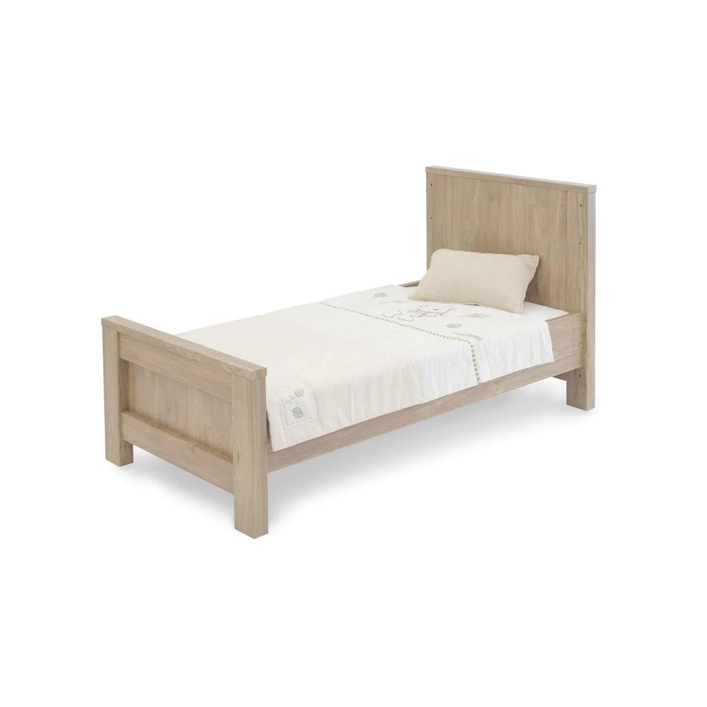 Oak wood cot bed with headboard, footboard, and white bedding set