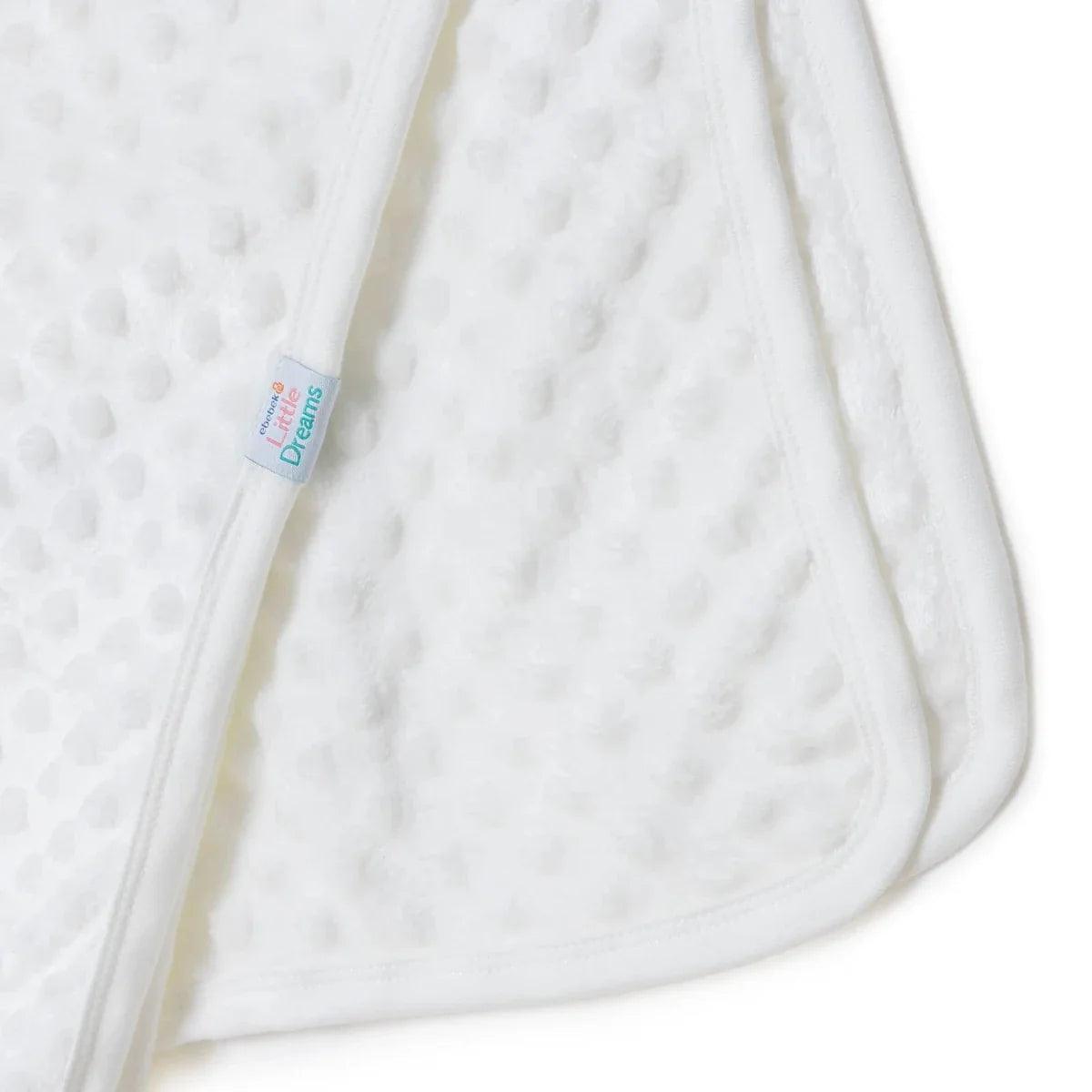 Ecru fleece baby blanket edge with “Little Dreams” label, textured dot pattern