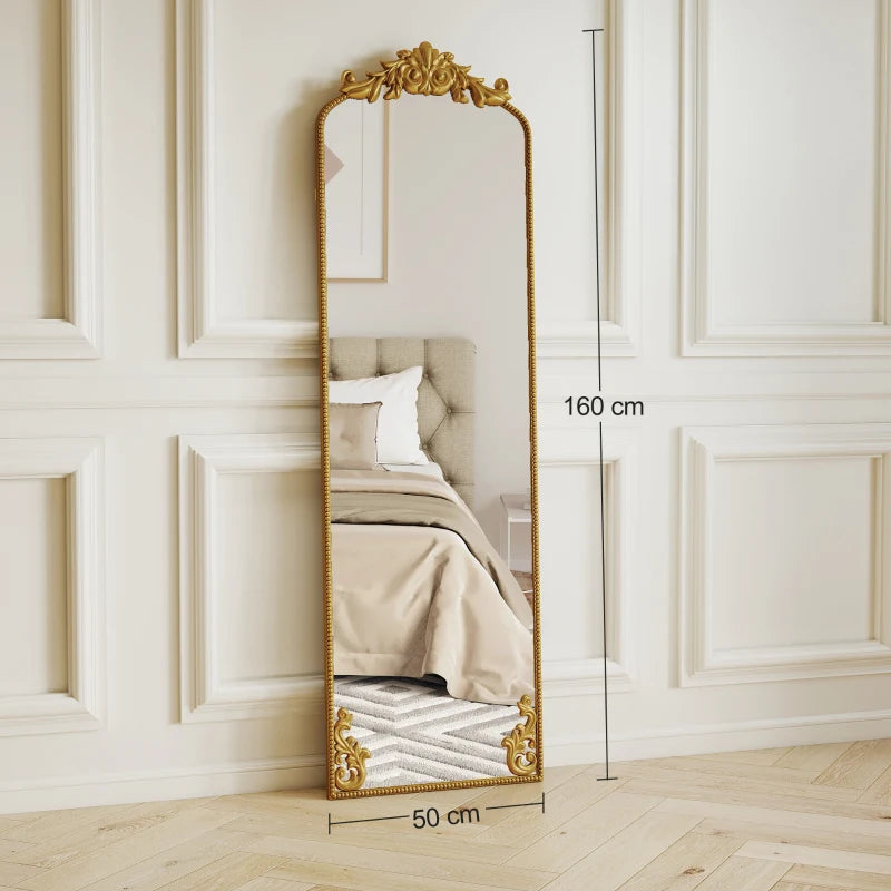Full length floor mirror with decorative baroque gold frame, standing against wall