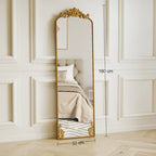 Full length floor mirror with decorative baroque gold frame, standing against wall