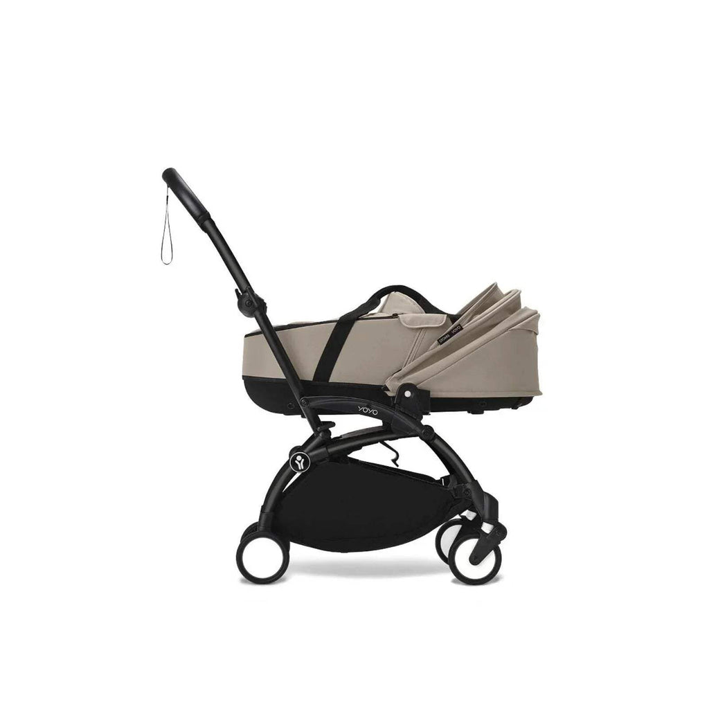Taupe newborn shell on stroller, side view with black frame and hood up