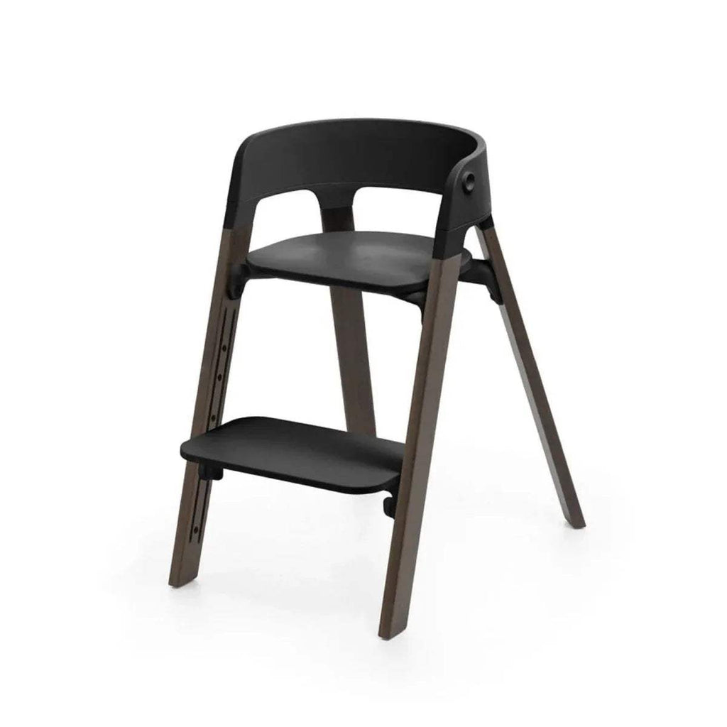 Black highchair with compact two-level design, rounded seat, warm brown legs