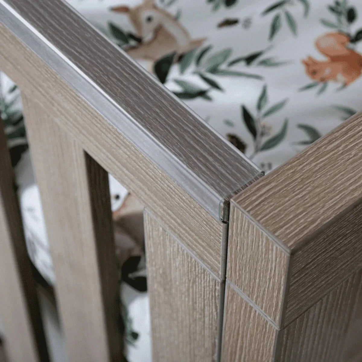 Oak cot corner with vertical slats and latch detail