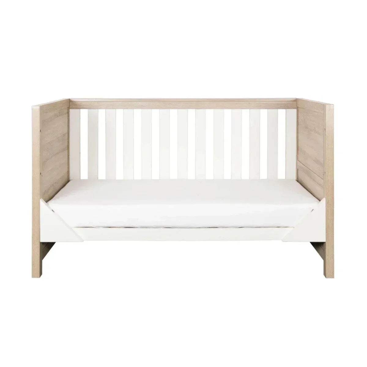 Oak and white wooden cot bed with vertical safety slats and mattress