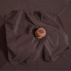 Brown umbrella canopy close-up with round finial at the center