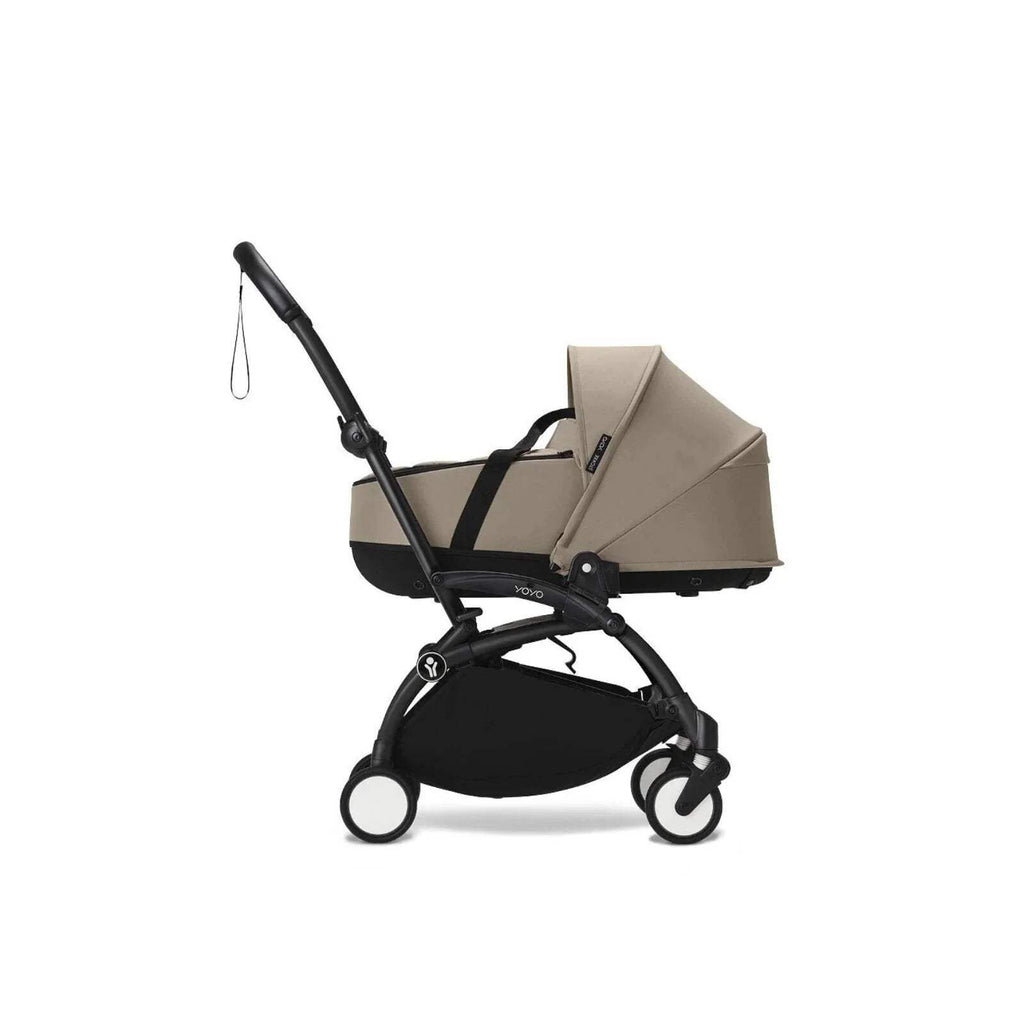 Taupe newborn shell on stroller with black frame, hood up and front panel