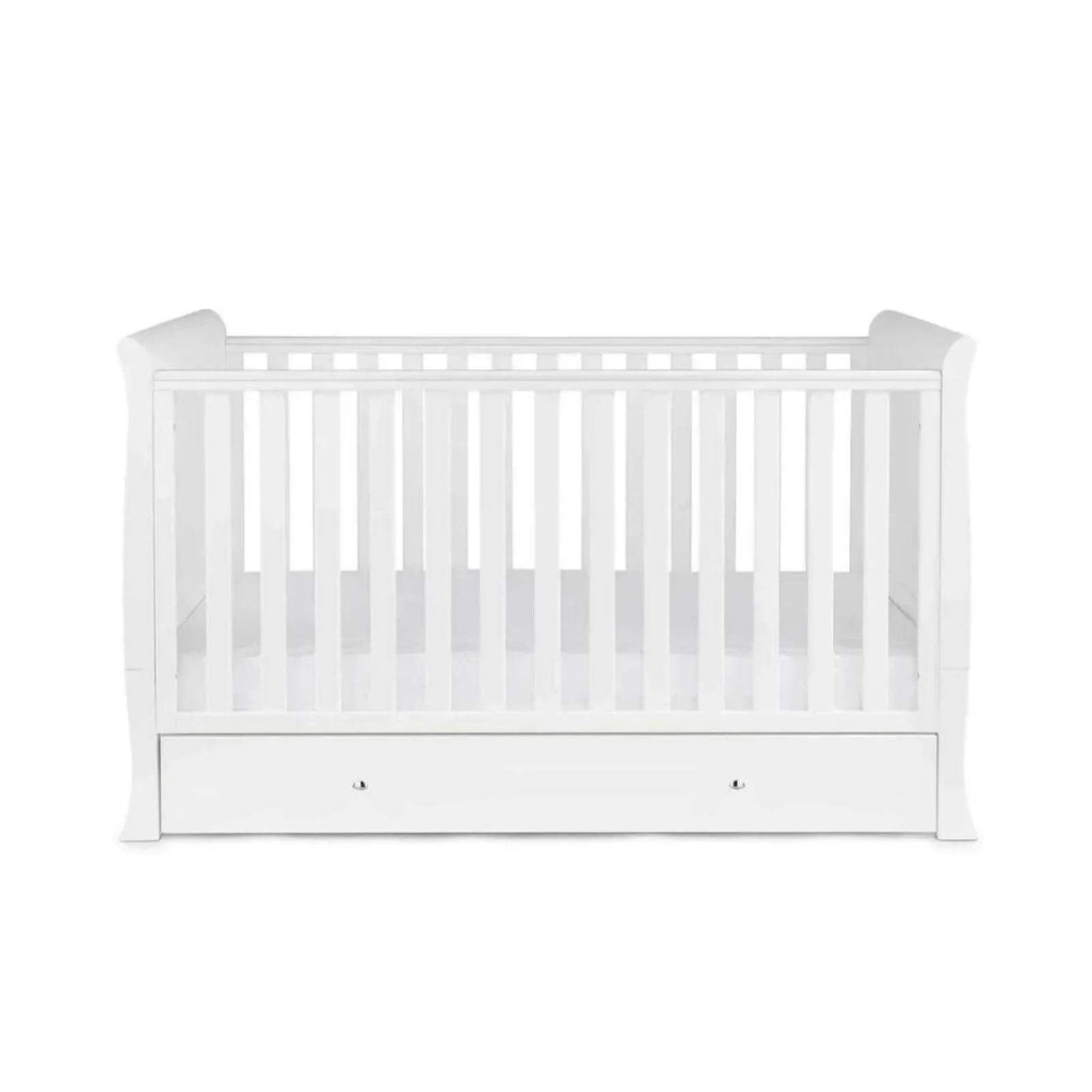 White baby cot with vertical slats and centered front drawer panel
