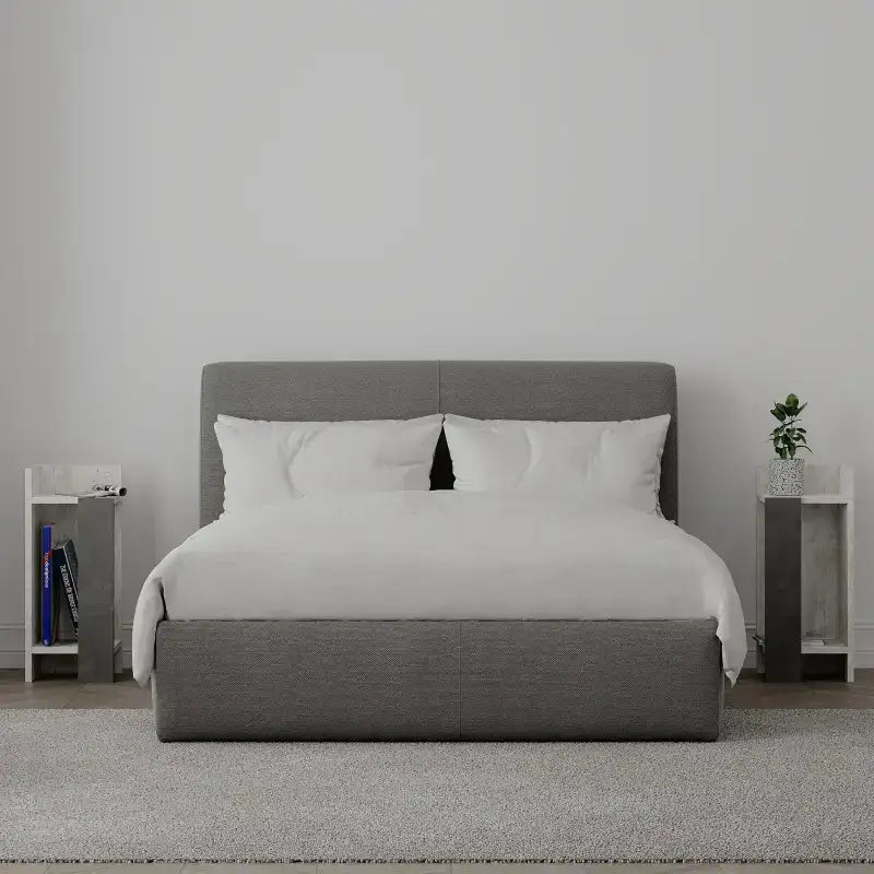 Modern narrow bedside table with open shelf, grey body and white top, front view.