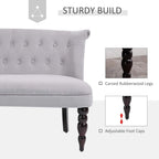 Grey velvet loveseat with button-tufted back and carved rubberwood legs