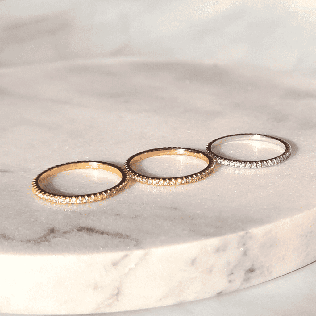 Three thin full eternity rings with pavé stones in gold and silver tones