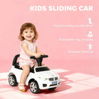 White kids sliding car with black steering handle and toddler seated