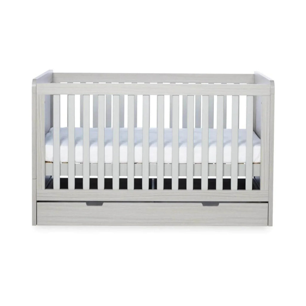 Ash grey cot bed front view with white mattress, slatted sides, and drawer section