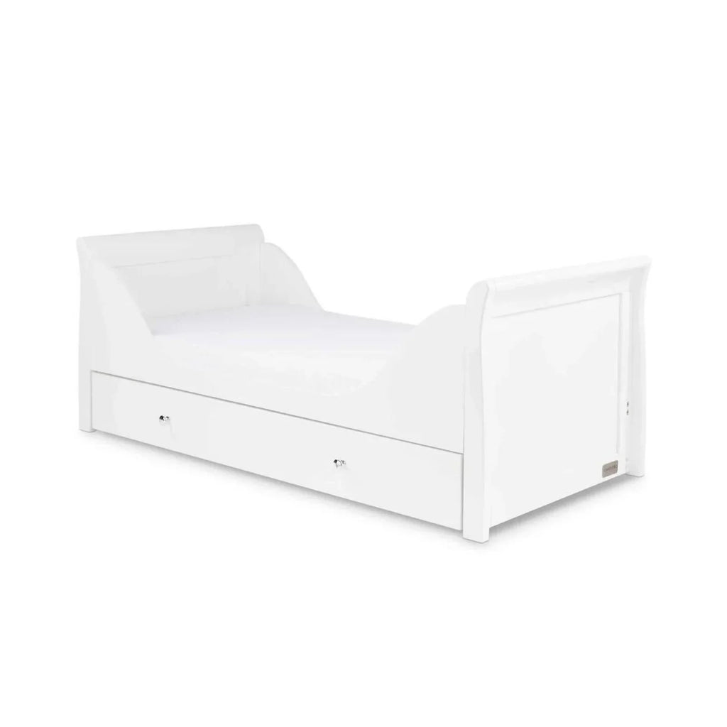 White cot bed with curved headboard, side panels, and drawer front