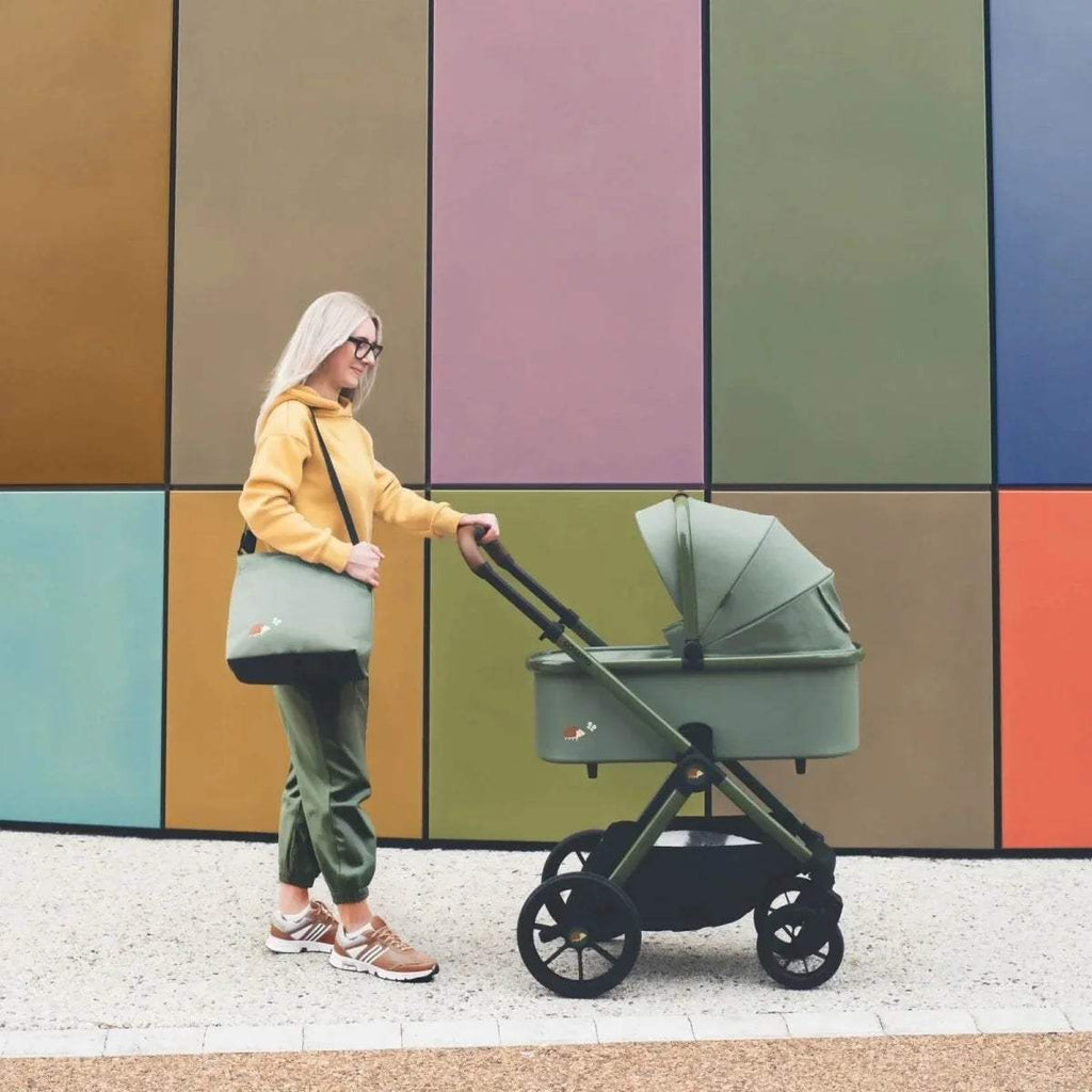 Green pushchair with pale hood and padded seat, four-wheel stroller