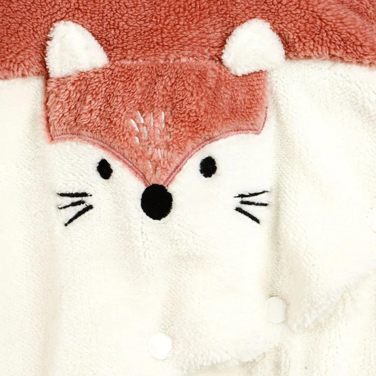 Fox-themed hooded jumpsuit face patch with embroidered eyes and nose on cream panel.