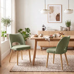 Green upholstered dining chairs with curved backs and tapered light wood legs, set of 2