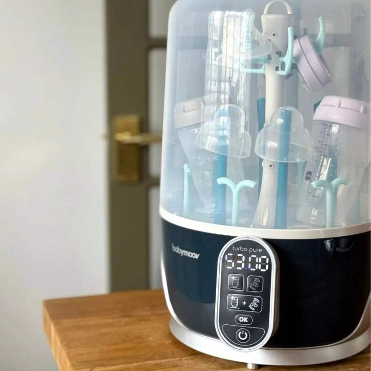 Babymoov Turbo Pure steriliser and dryer with bottle rack inside and illuminated control display