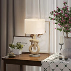 Hemp rope bedside table lamp with white fabric shade on a wooden surface