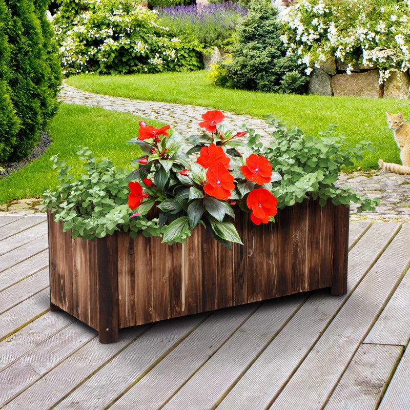 Wooden raised garden bed with dark carbonized finish, filled with flowers and green plants