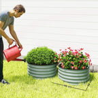 Two green ribbed metal planter boxes in a grass garden bed