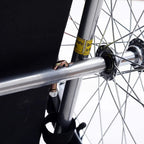 Steel bicycle frame wheel hub and hitch connector on red and black pet trailer