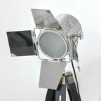 Tripod floor lamp spotlight head with circular lens and silver protective panels