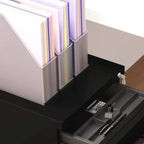 Black 3-drawer filing cabinet with open drawer and pen/pencil tray, lock key visible