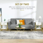 Set of two white nightstands with gold legs, drawers, and open storage shelves