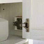 Metal hinge with screws on white cabinet door, showing interior shelf behind