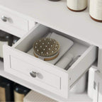 Close-up of white bathroom cabinet drawer with metal knob and open storage compartment