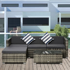 Grey wicker sectional sofa set with chaise, dark cushions, striped pillows and matching table