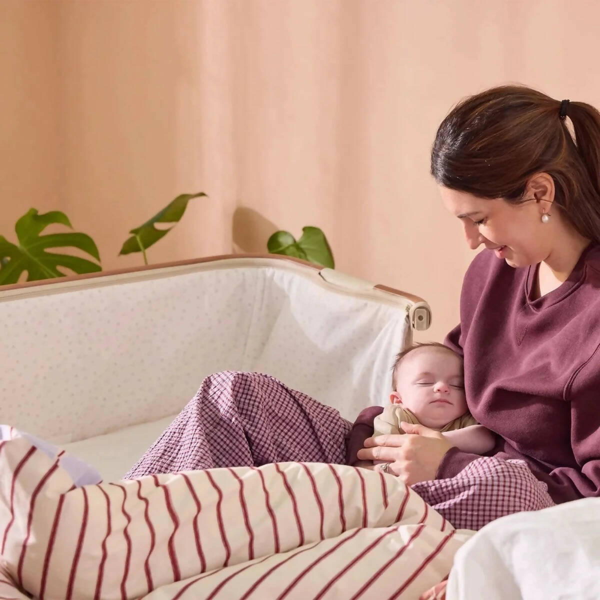 Ecru bedside crib with padded mattress and open side panel