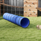 Blue foldable dog tunnel with dark ring seams, placed on a lawn near obstacles