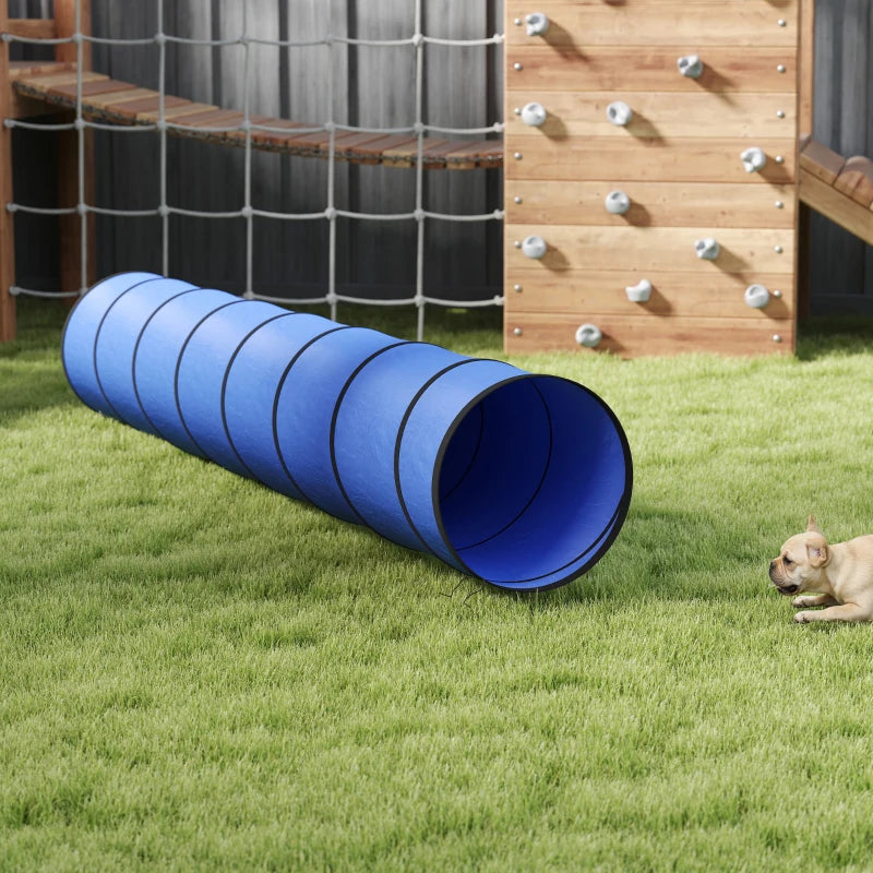 Blue foldable dog tunnel with dark ring seams, placed on a lawn near obstacles
