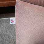 Light pink upholstered ottoman bench corner with fabric texture