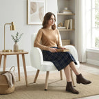 Cream velvet upholstered armchair with padded backrest, rounded arms, and wooden legs