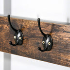 Two black metal coat hooks on rustic brown wooden rail