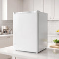 White single-door mini fridge placed on a kitchen countertop with door closed