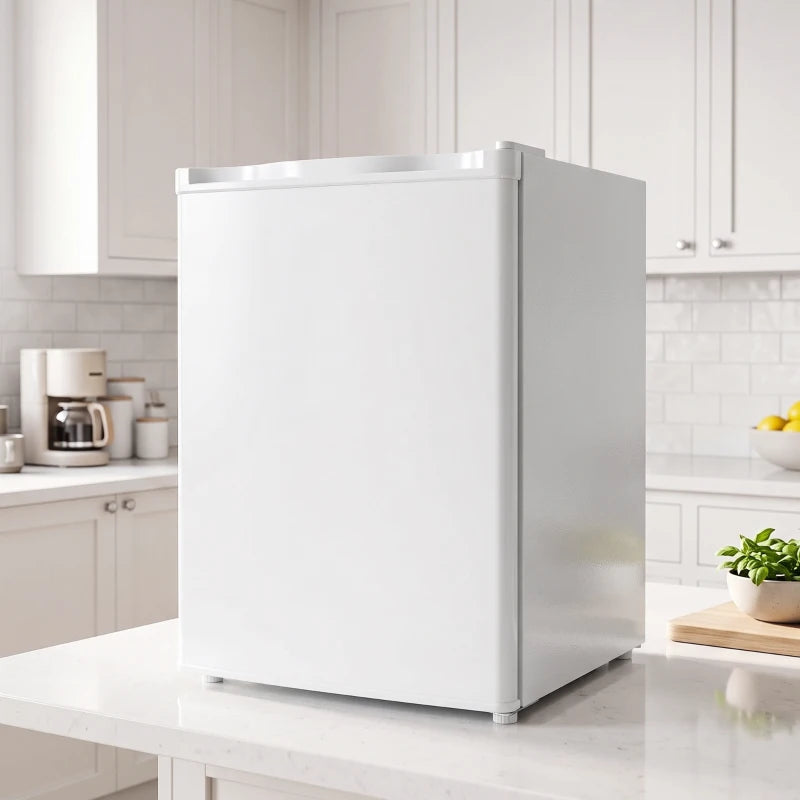 White single-door mini fridge placed on a kitchen countertop with door closed
