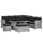 Grey rattan corner sofa set with black tufted cushions and matching footstools