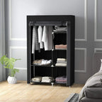 Black foldable fabric wardrobe standing in a room with open door and organized shelves.