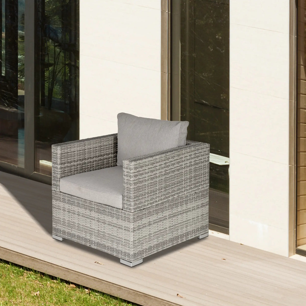 Grey wicker armchair with padded cushions and broad woven armrests
