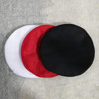 Two replaceable stool seat covers stacked: black and red with white cover